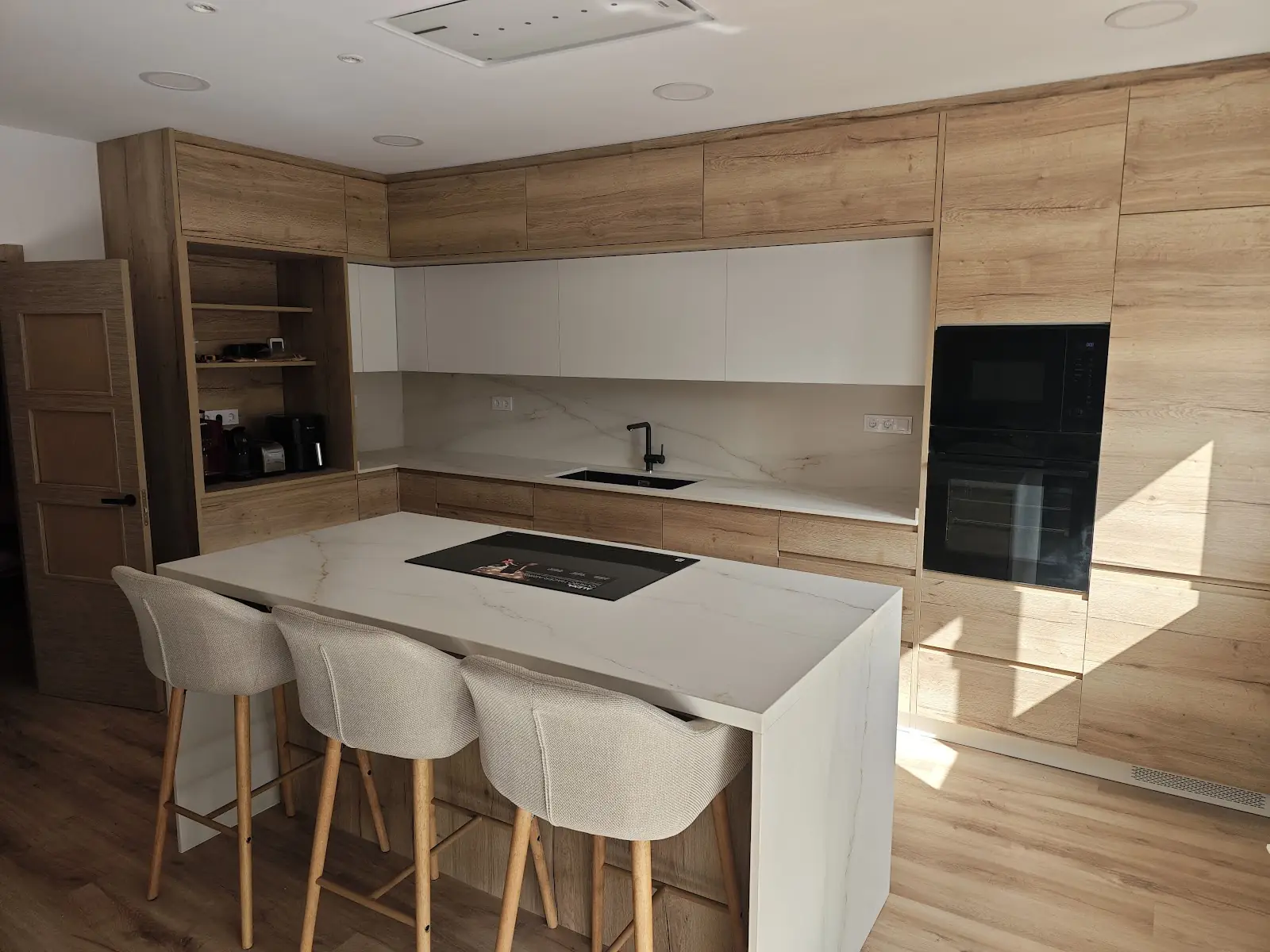 Cocina reformada estilo americano con isla en una vivienda de Sabadell
